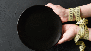 czarny talerz, ręce owinięte miarą krawiecką